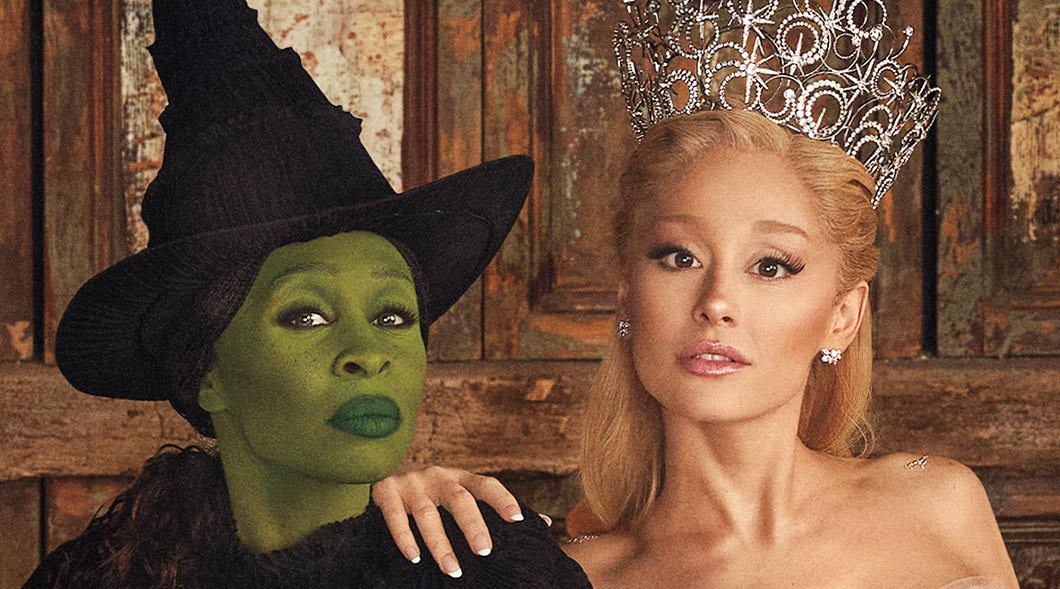 Two performers in Wicked costumes, one in green witch makeup and one in a jeweled crown